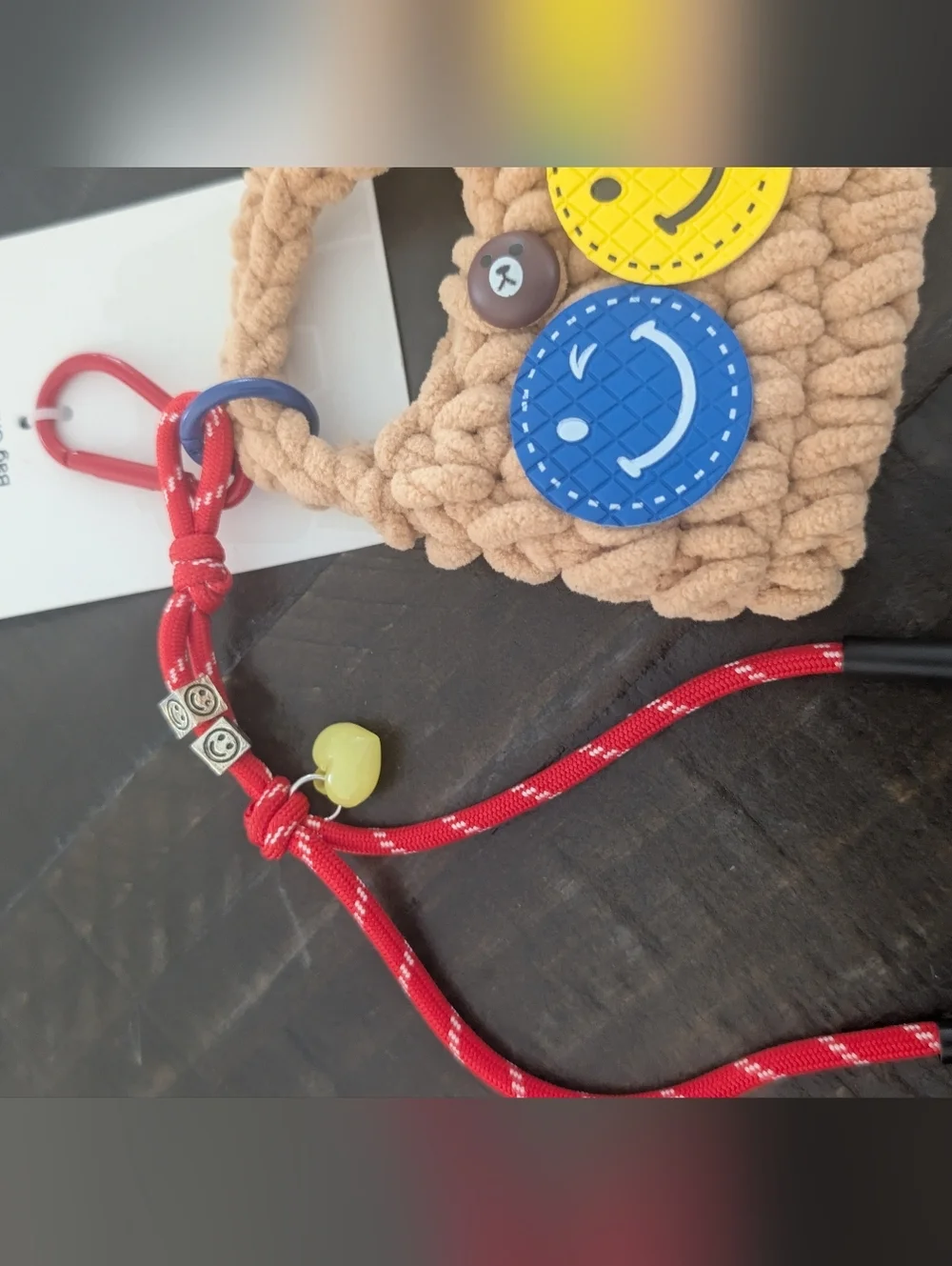 Full Tilt Beige Crochet Kids Bag Charm with Blue & Yellow Smiley Faces